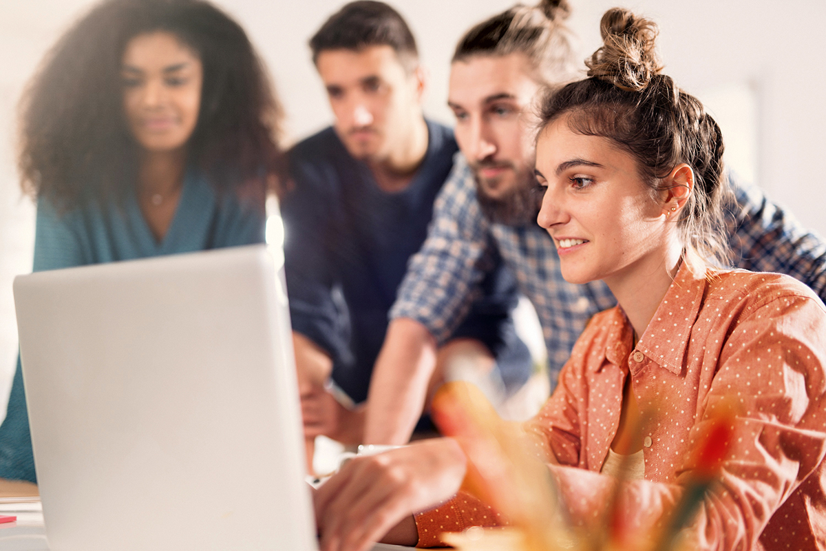 Studenten tauschen sich gemeinsam am Laptop aus.