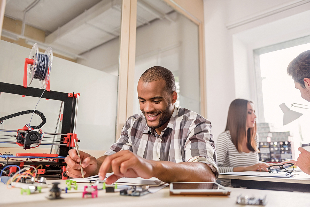 Fröhlicher Jungdesigner testet 3D-Druck