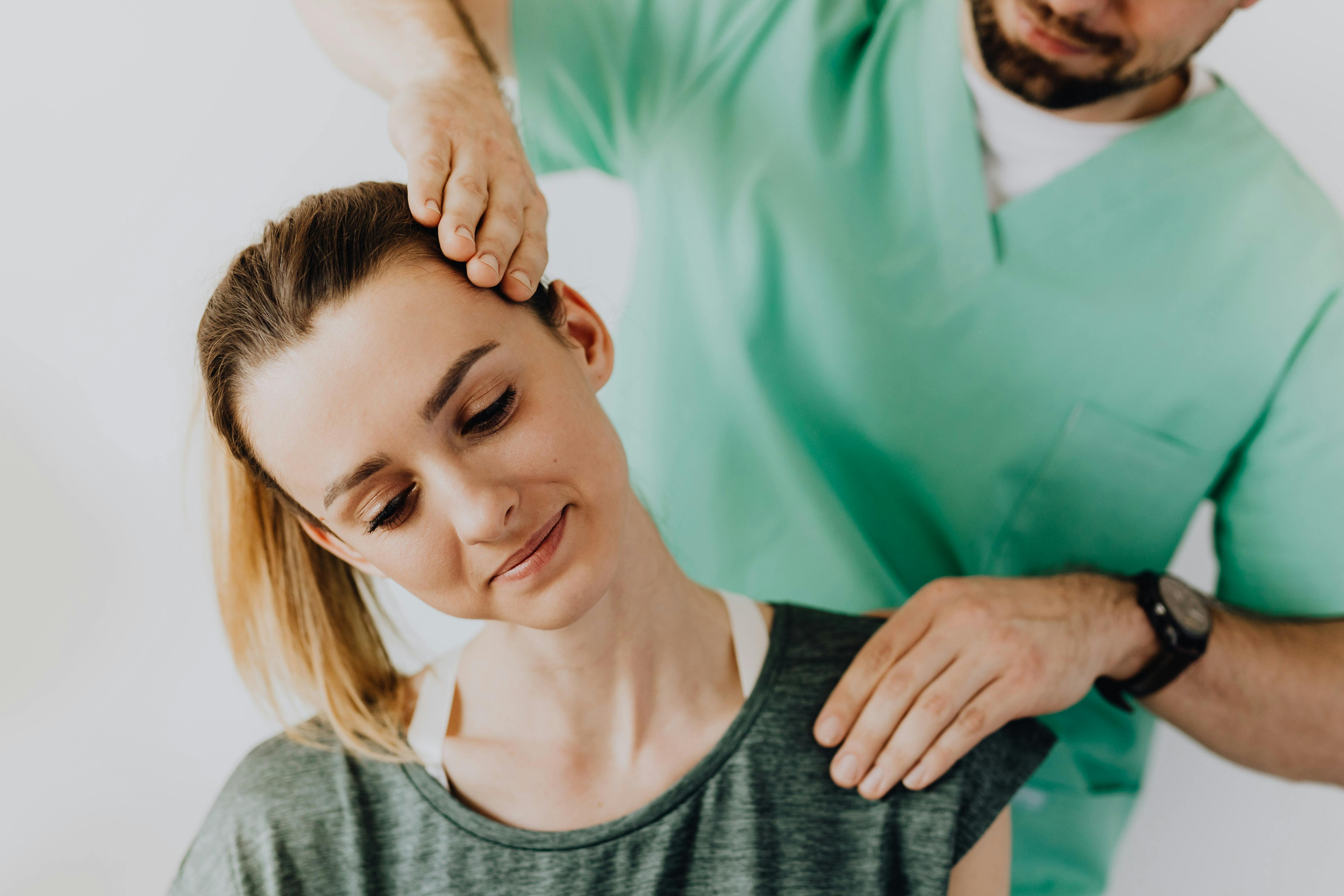 Kategorie Therapie studieren Studium SRH University A woman is receiving a neck massage from a male therapist. The therapist has his hand on her head while she looks relaxed. Both are wearing comfortable clothing.