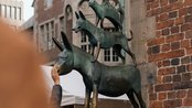 Bronzeskulptur der Bremer Stadtmusikanten, bestehend aus einem Esel, einem Hund, einer Katze und einem Hahn, auf einem Sockel.