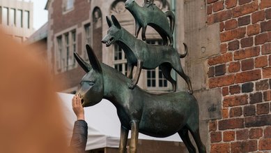 Bronzeskulptur der Bremer Stadtmusikanten, bestehend aus einem Esel, einem Hund, einer Katze und einem Hahn, auf einem Sockel.