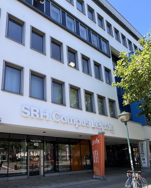 SRH Campus Leipzig Header neu SRH Campus Leipzig with an entrance area and signs. Bicycles are parked in front of the building, which showcases modern architecture.