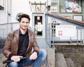 Portraitfoto Student vor dem Eingang der CARITAS