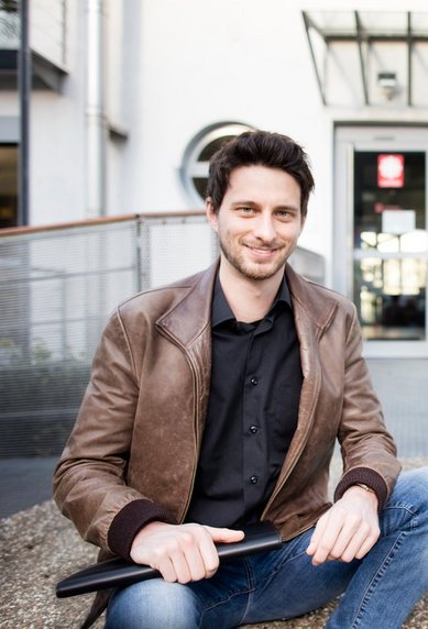 Portraitfoto Student vor dem Eingang der CARITAS