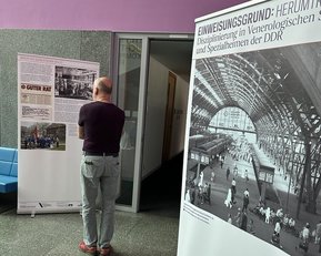 Ein Besucher betrachtet zwei Ausstellungstafeln, die Informationen über die Disziplinierung in der DDR und historische Fotografien zeigen. Eine Tafel enthält den Titel "GUTER RAT". Der Raum hat eine moderne Architektur.