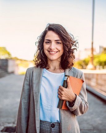Studentin mit Gesetzesbuch in der Hand vor dem Gericht