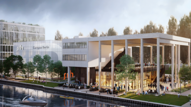 Moderne Architektur des SRH Campus Berlin, mit einem großen, lichtdurchfluteten Gebäude und einer Terrasse am Wasser. Bäume und eine Uferpromenade umgeben das Gelände, während Boote auf dem Wasser fahren.