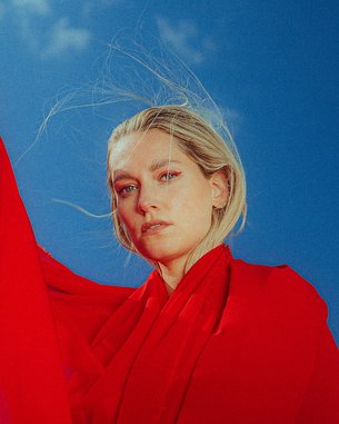 Woman in a red dress against a blue background.