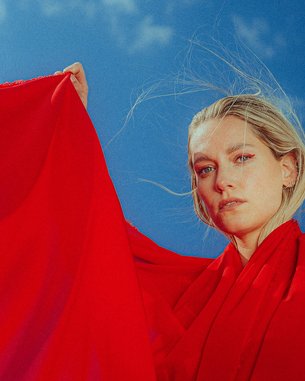 Woman in a red dress against a blue background.