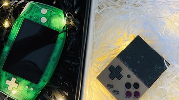 Three portable gaming consoles in decorative boxes with colorful filling material. A silver, a green, and a black console are visible.