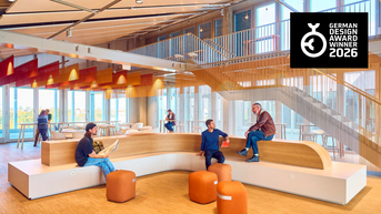 Modern interior design with seating in a bright room. People are interacting and relaxing in a creative environment.