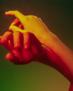 Hands in various skin tones touching and intertwining. The hands are set against a soft, multicolored background that includes shades of green and yellow.