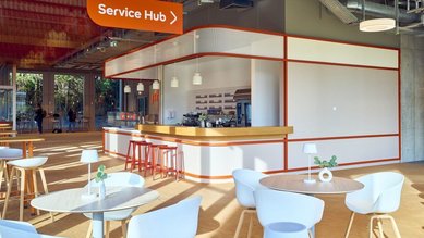 Modern service hub with a counter, chairs, and tables. Bright, open atmosphere with minimalist decor.