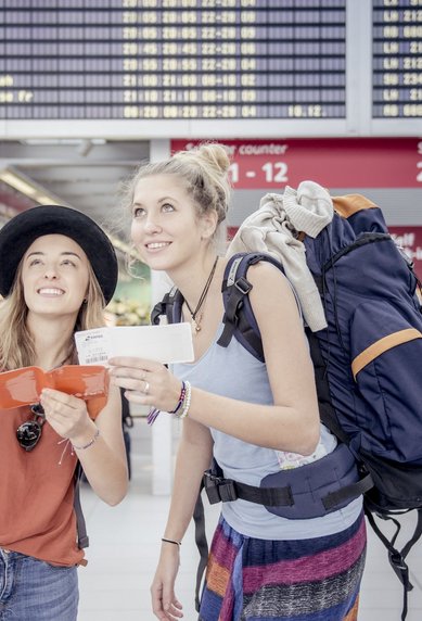 Zwei Studierende am Flughafen mit Gepaeck