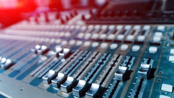A mixing console with several knobs and sliders, used for audio editing.