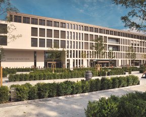 Modern architecture of a building with large windows, surrounded by well-maintained green spaces and trees.