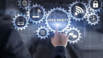 A man in a suit is touching a digital display featuring symbols for networking technologies, including IEEE 802.11 and various communication icons.