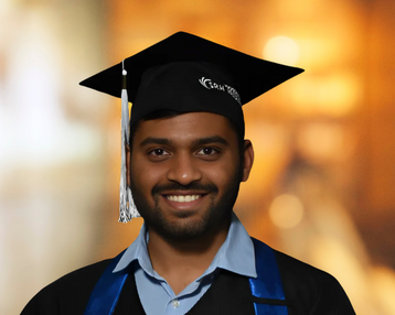 Ein graduierter Student trägt eine Abschlussmütze und einen Umhang, lächelt in die Kamera und steht vor einem unscharfen Hintergrund.